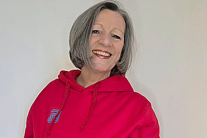 Porträt einer Frau um die 60 Jahre mit rotem Pullover