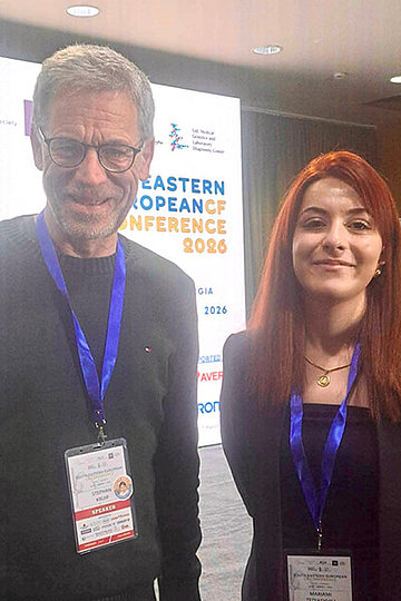 Mann - um die 60 Jahre alt - und jüngere Frau schauen in die Kamera