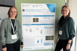 Maike Karnstedt und PD Dr. Hentschel Zwei Frauen stehen rechts und links einer Posterwand, die Forschungsergebnisse aufzeigt