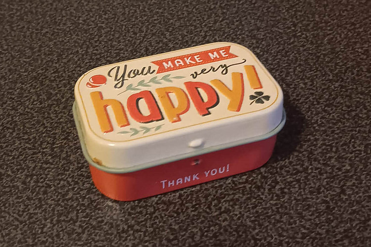 Bild einer kleinen Tablettendose mit der Schrift "You make me very happy"