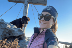 Selbstportrait junge Frau mit Hund vor Gipfelkreuz