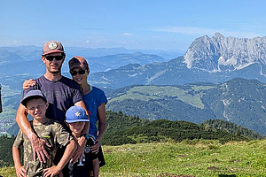 Daniela und ihre Familie Familienfoto: Eltern, zwei Jungen vor Bergkulisse