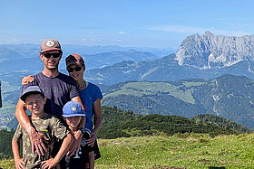 Familienfoto: Eltern, zwei Jungen vor Bergkulisse