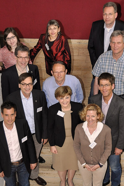 Elf Personen, darunter vier Frauen, stehen auf einer Treppe für eine Foto angeordnet. Das Foto wurde im Jahr 2024 aufgenommen und zeigt den damaligen Vorstand des Mukoviszidose e.V. 